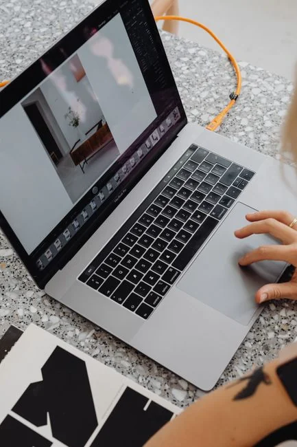 our-story Close-up of hands interacting with a shopping website on a laptop screen indoors.